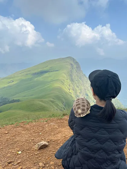 A trekker with a tortoise shell on her back, adding a touch of fun to the Netravathi adventure.