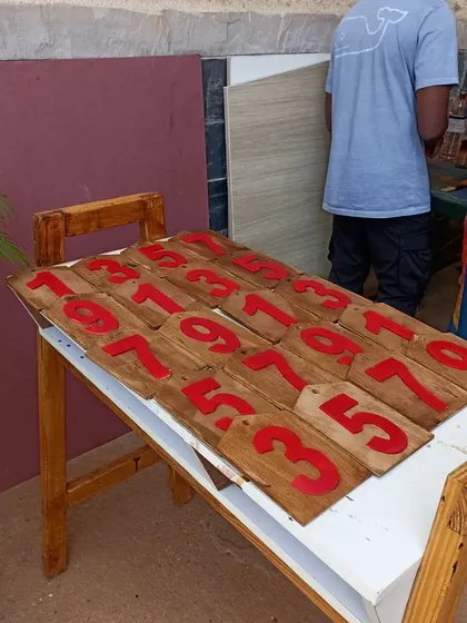 The finished number panels for the scoreboard, ready for assembly. The bright red numbers stand out clearly against the dark walnut stain.
