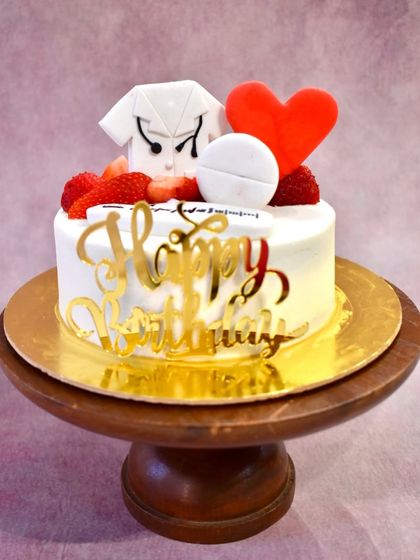 A simple yet sweet strawberry-flavored cake for a doctor, topped with a fondant doctor's coat, a heart, and fresh strawberries.