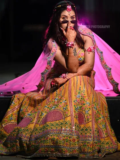 A full-length shot showcasing the contrast between the traditional lehenga and the modern, edgy styling.