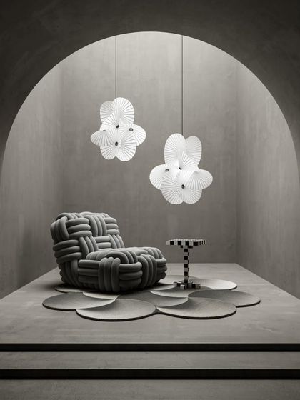 Two Serpentine Lights are paired in a minimalist, gallery-like space, their sculptural forms interacting with the unique furniture to create a highly curated and artistic composition.