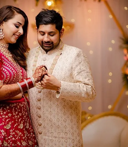 A sweet moment from a wedding day, where the groom admires his bride's henna-adorned hand.