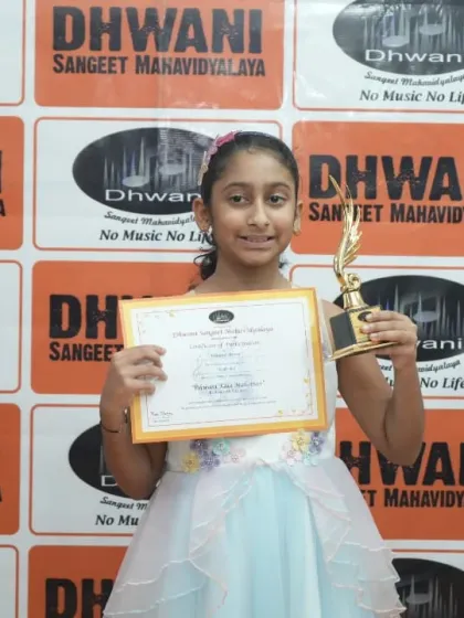 A young artist in a beautiful dress, proudly holding her award and certificate.