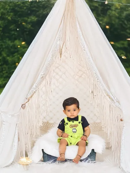A magical twilight outdoor session. The glowing star props and teepee create an enchanting atmosphere for this little boy's portrait in the park.