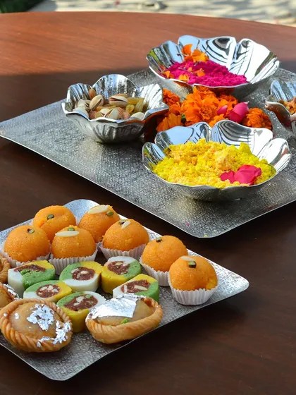 Getting ready for Holi with a spread of sweets and colors. My square and floral-shaped nickel-finish trays and bowls are perfect for serving gujiyas, laddoos, and holding gulaal.