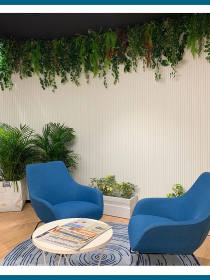This cozy seating nook is made even more inviting with a combination of real potted palms and an artificial hanging garden above. This shows our balanced approach, using both real and artificial plants to achieve the best result for the space.