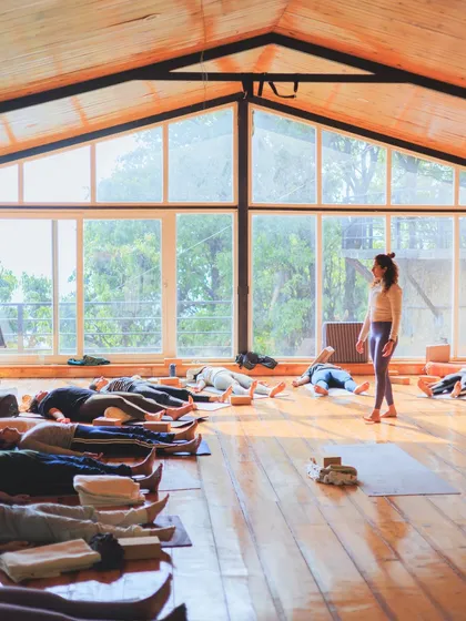 Guiding students into Savasana (Corpse Pose) in our sunlit shala. This is a sacred time for integration, allowing the benefits of the practice to settle in.