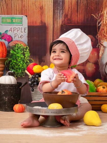 Another angle from the little chef shoot. Her joyful smile and the colorful props make this a truly delightful and memorable photo.