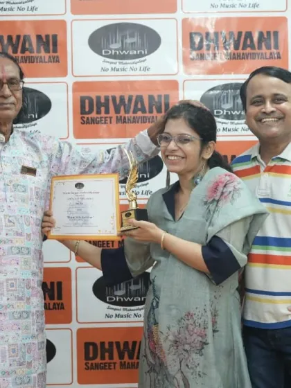 An adult student receives her award from our senior guru, joined by her proud husband.