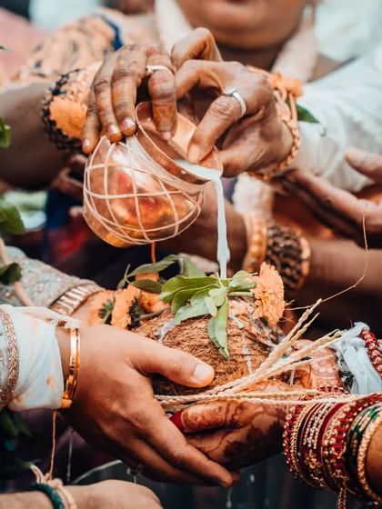 A detail shot of a sacred wedding ritual involving the pouring of milk over a coconut, highlighting the cultural significance of the ceremony.