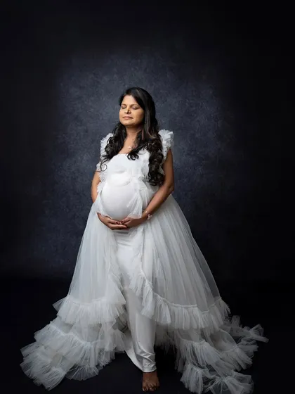A moment of quiet reflection. This portrait captures the mother-to-be with her eyes closed, connecting with her baby in a serene and personal way.