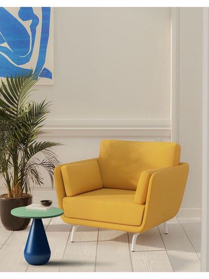 The 'Bernard and friends' side table, with its distinct turned wood base, paired with a modern armchair. The collection is designed to complement a variety of interior styles while adding a touch of artisanal quality.