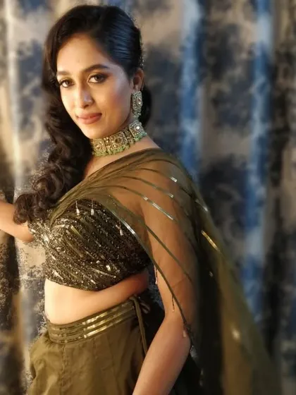 A stunning portrait of the bride at her engagement party. Her side-swept curls and glamorous makeup perfectly match the modern, chic vibe of her outfit.