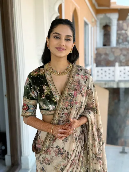 This full-length view shows how a soft glam makeup look pairs beautifully with an elegant floral saree for a chic daytime event.