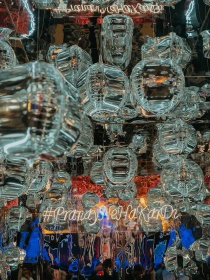 A creative photo-op with a ceiling of silver balloons and a custom neon hashtag, creating a fun and immersive spot for guests to capture memories.