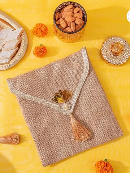 A beautiful wedding favor, this jute envelope is adorned with a lotus motif and tassel, perfect for a traditional wedding.