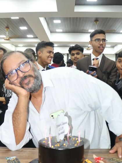 A candid and fun moment with one of our senior teachers posing with the farewell cake.