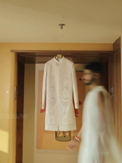 An artistic shot of the groom getting ready, using motion blur to create a dynamic feel, with his sherwani in sharp focus.