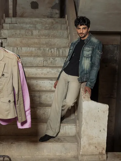 A relaxed, full-length shot in a rustic, industrial setting. This adds an environmental element to the portfolio.