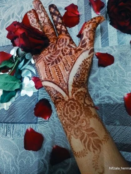 The classic combination of a dark henna stain and red roses. This photo captures the romance of a wedding.