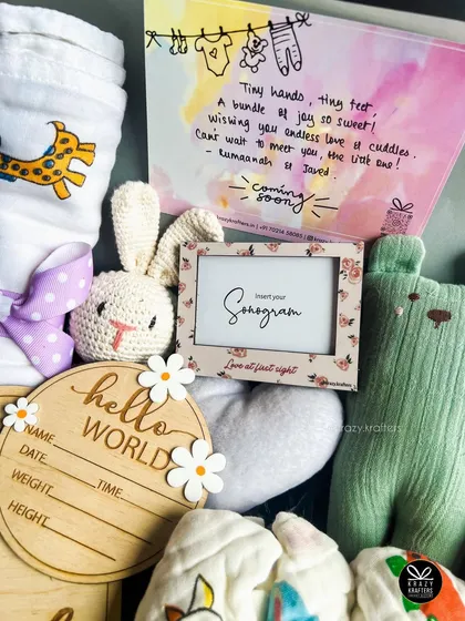 This shot highlights the personalized card and the 'Hello World' wooden milestone plaque, perfect for capturing those precious early moments.