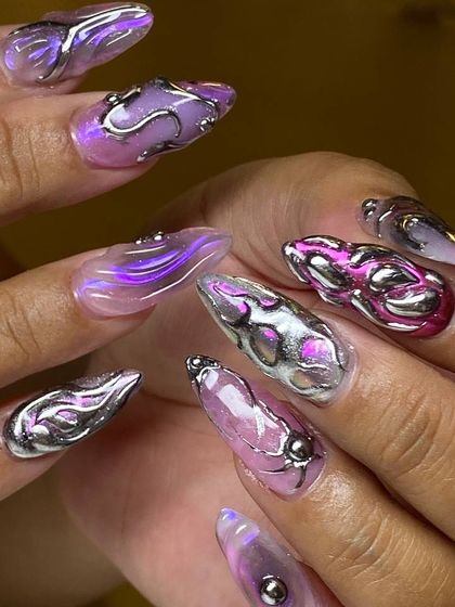 A futuristic and edgy 3D chrome nail art set. This design uses sculpted silver and pink metallic gels to create an incredible, multi-dimensional liquid metal effect.