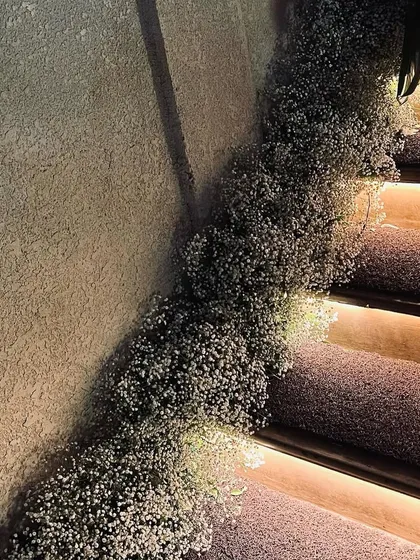 A staircase elegantly decorated with a cascade of baby's breath, adding a touch of romance and whimsy to the venue.