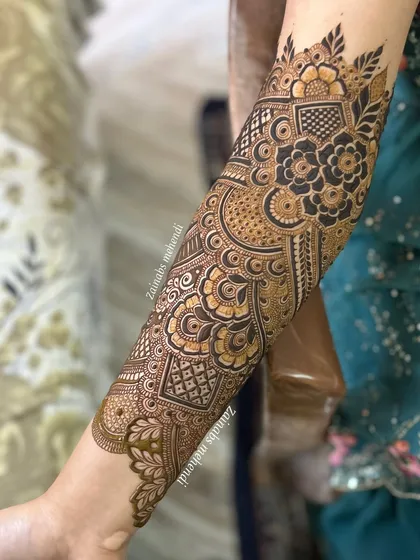 A side view of Sana's bridal arm, highlighting the flow of the design and the mix of different motifs.