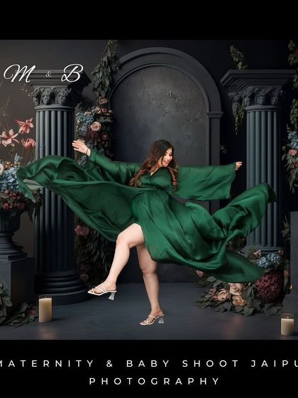 A dynamic and powerful studio shot of a woman in a green gown, captured mid-motion. The dark, classical-inspired backdrop with pillars and florals adds a dramatic and artistic flair.