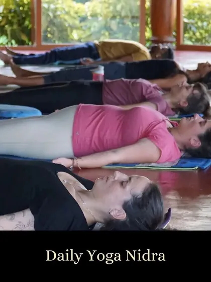 Students rest in Savasana during a daily Yoga Nidra session. This guided meditation promotes deep relaxation, helping to release stress from the subconscious mind.