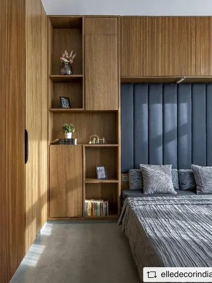 The guest room features a comfortable Murphy bed flanked by custom wooden cabinetry with integrated shelving and fluted panel details, maximizing both style and function.