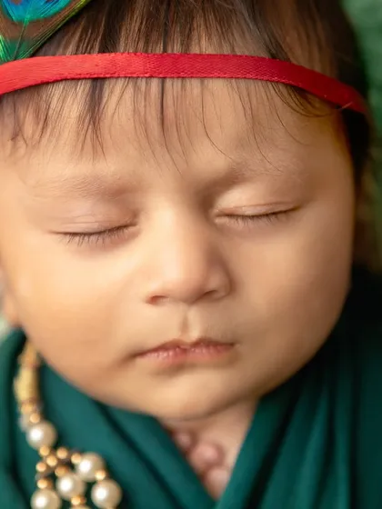 Another beautiful close-up of our sleeping baby Krishna. The focus is on the peacefulness and innocence of the newborn.