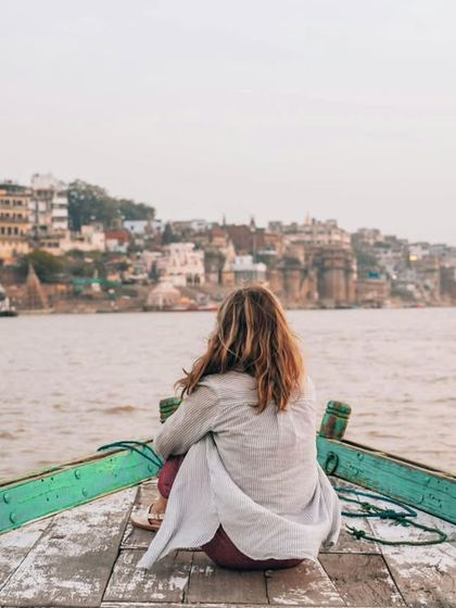A quiet moment of reflection on the Ganga. This portrait captures the serene experience of a traveler finding tranquility in the heart of Banaras.