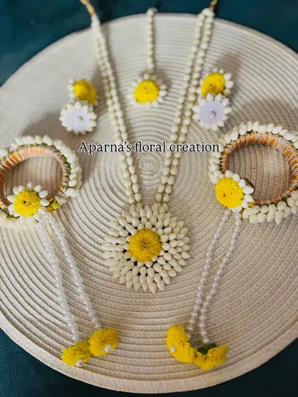 A classic Haldi jewellery set made with jasmine buds and bright yellow flowers. This set includes a necklace, earrings, maang tikka, and haath phool with kalire.