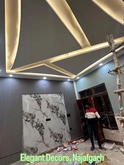 This is a look at a project in progress, showing the complexity I handle. You can see the geometric false ceiling with its lighting framework, a wall featuring grey fluted panels, and a central accent wall prepared for a UV marble sheet. I manage the entire process from start to finish.