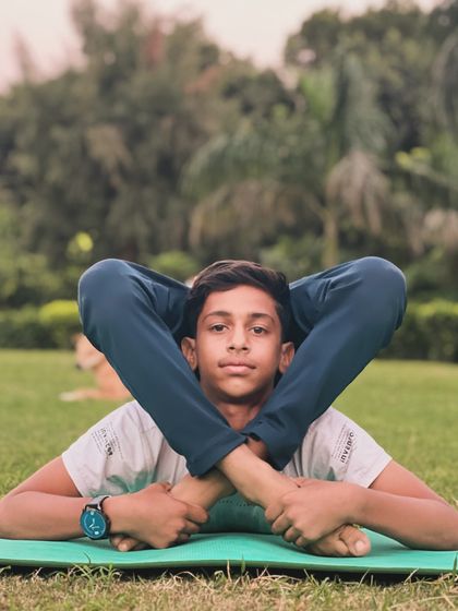 This lying-down contortion pose brings the legs behind the head, showcasing amazing hip and spine flexibility. Try it.