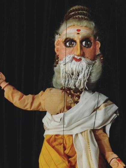 A puppet depicting the sage Kanva from our production of "Abhijnaana Shaakuntalam." The character's wisdom and gentle nature are conveyed through his expressive, hand-painted face and simple attire.