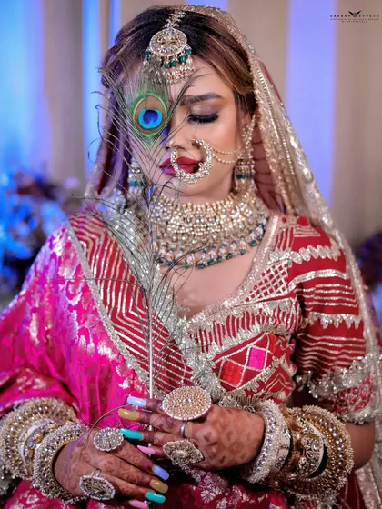 A creative portrait using a peacock feather to partially cover the bride's face, adding an artistic touch.