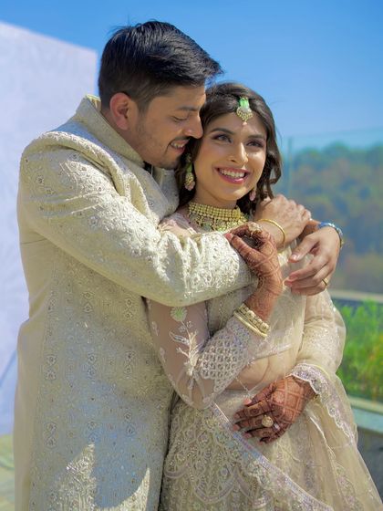 A warm, candid embrace under the sun. This photo perfectly captures the couple's affection and the happy glow of their wedding day.