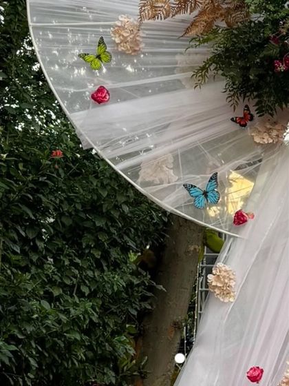 More detail of the delicate butterflies and flowers attached to the white bow entrance, showing the craftsmanship involved in creating these custom pieces.