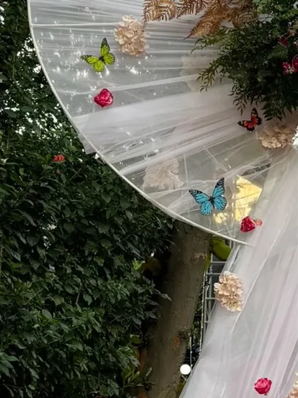 More detail of the delicate butterflies and flowers attached to the white bow entrance, showing the craftsmanship involved in creating these custom pieces.