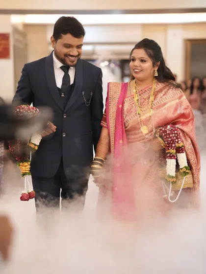 The grand entrance. This couple walks through a cloud of smoke, and the bride's makeup remains flawless and radiant.