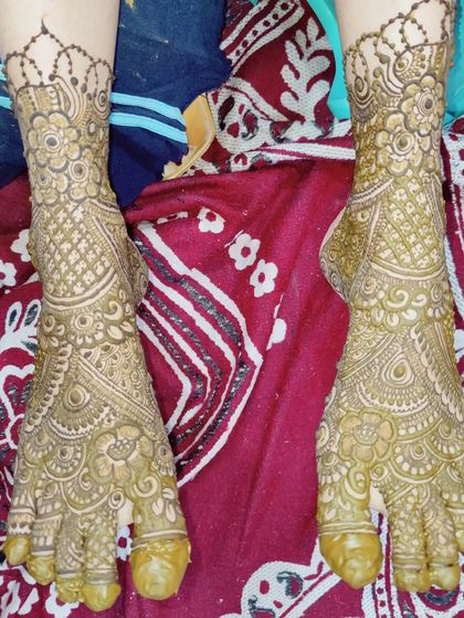 A lovely and intricate design for bridal feet, featuring a central mandala and detailed work extending up the ankles.