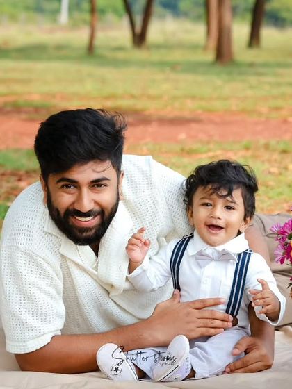 A joyful shot of a father and son laughing together during their outdoor family session.