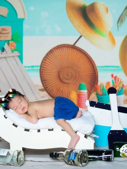 A full view of the 'beach bum' setup, showing the baby sleeping peacefully amidst the party leftovers.