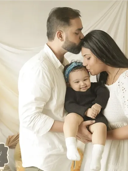 A family united in love. This portrait captures the protective and gentle embrace of new parents with their baby, a perfect 'family forever' moment.