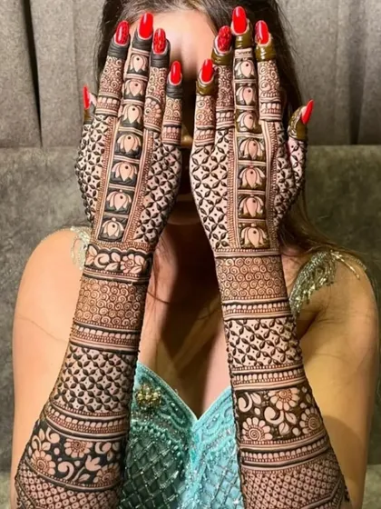 A full bridal design is a statement. This intricate pattern, featuring traditional elephant motifs, covers the hands and arms in a stunning display of detailed henna art.