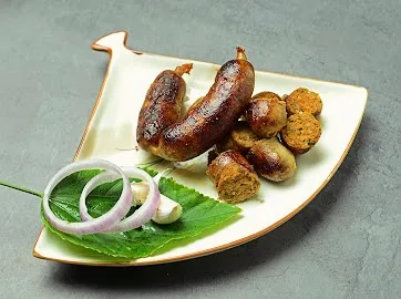 Our handmade Thai Sai Oua pork sausages, beautifully plated and ready to eat. These are packed with the fresh flavors of Thai galangal, lemongrass, and kaffir lime, offering a zesty and aromatic experience.