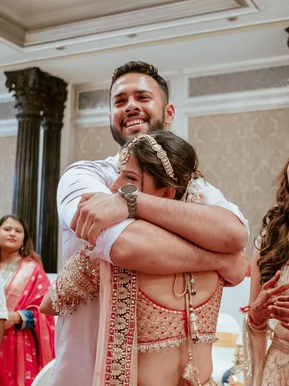 A bride's bond with her brother is special. This emotional hug captures the mix of joy and bittersweet feelings on a wedding day.
