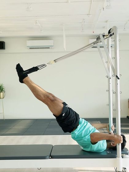 Our expert coach demonstrates a challenging inversion on the reformer tower. This move builds upper body strength and decompresses the spine.